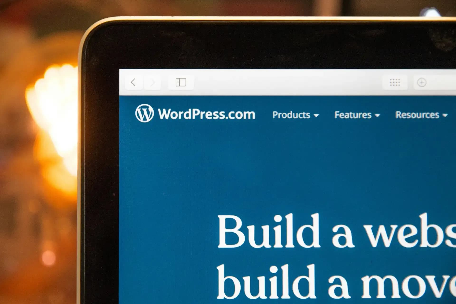 Tela de notebook exibindo o site WordPress.com com menu de navegação no topo