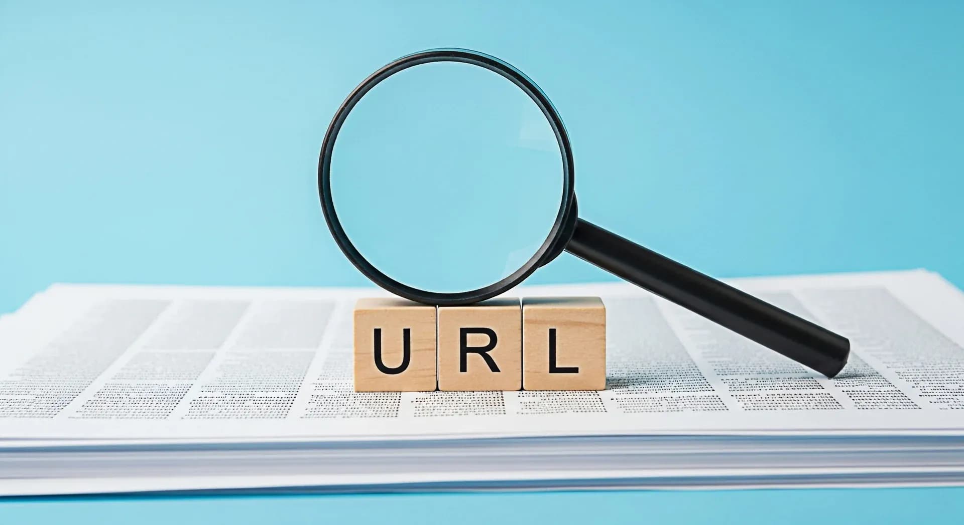 Lupa ampliando blocos com “URL” sobre páginas de jornal